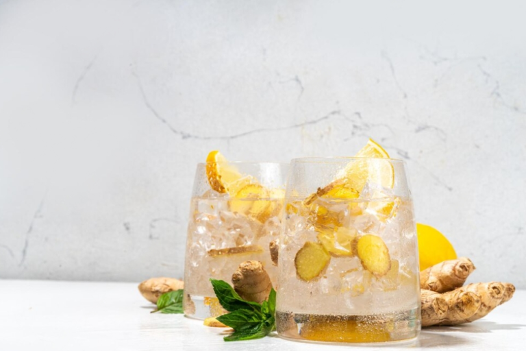 cocktails with ginger, mint, and lemons on a white table