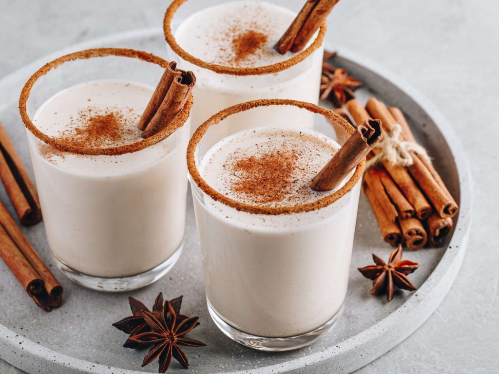 Three cocktails on a plate with cinnamon sticks