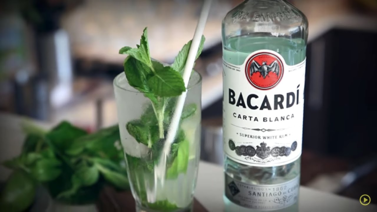 Bottle of bacardi next to a cocktail