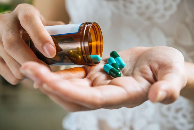 A woman takes pills out of a bottle