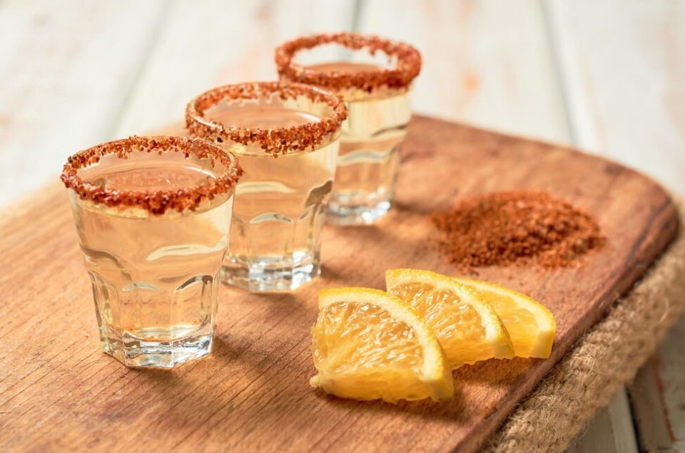 shots and lemon slice on wooden board