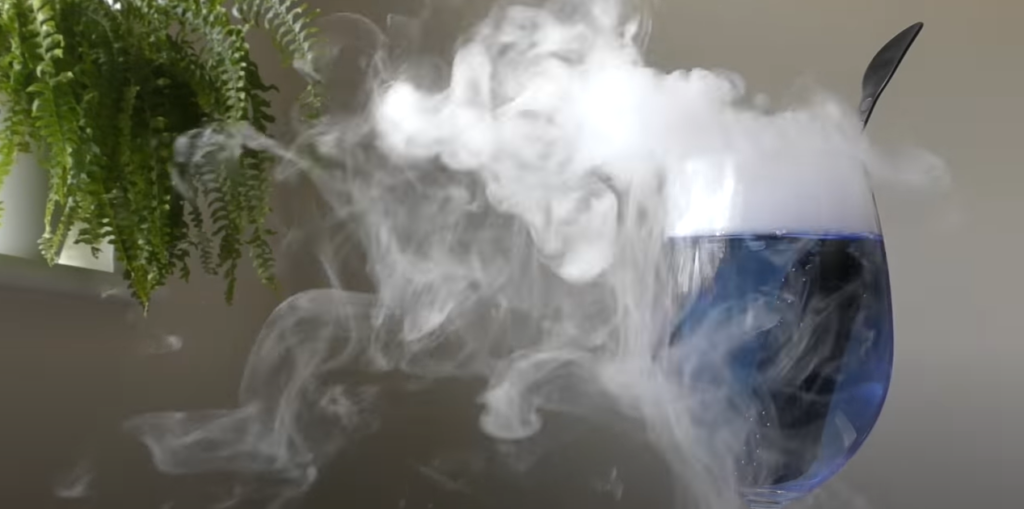 Blue cocktail in a wine glass with a cool and smoky appearance